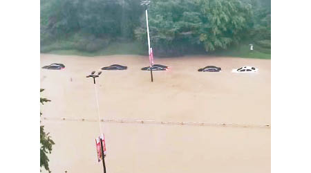 四川成都市龍泉區的馬路變河道，汽車幾近被淹沒。