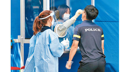 南韓疫情反彈，首爾市警員接受檢測。（美聯社圖片）