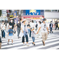 東京都疫情持續惡化，民眾仍須戴口罩防疫。（美聯社圖片）
