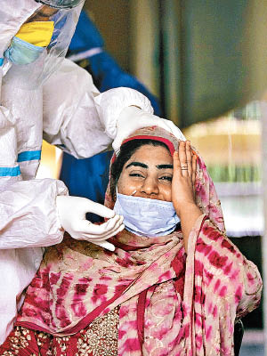 新冠肺炎肆虐印度，一名女子接受抽樣檢測。（美聯社圖片）