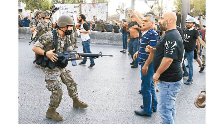 士兵持槍與示威者對峙。（美聯社圖片）