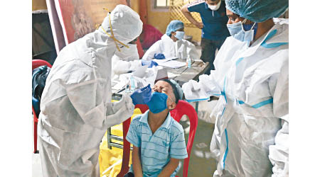 全球每日確診大批患者。圖為年輕孟買民眾接受採樣檢測。