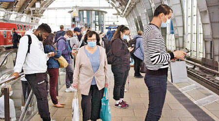 面對歐洲疫情反彈，德國民眾使用公共交通時戴口罩。（美聯社圖片）