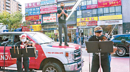 樂手在貨車前賣力演奏。（美聯社圖片）