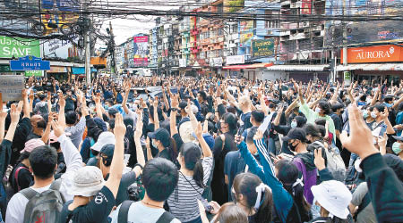 曼谷大批示威者舉起三指手勢。（美聯社圖片）