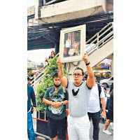 提迪瓦德向反政府示威者，高舉已故泰王蒲眉蓬及王太后詩麗吉的肖像。