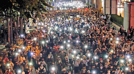 示威者出席集會，並亮起手機。（美聯社圖片）