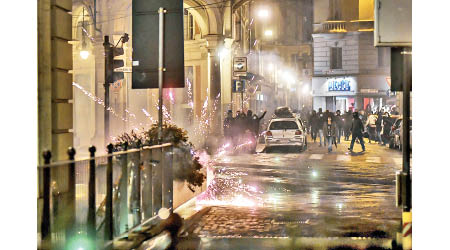意大利：都靈示威者在街頭發射煙花表達不滿。（美聯社圖片）