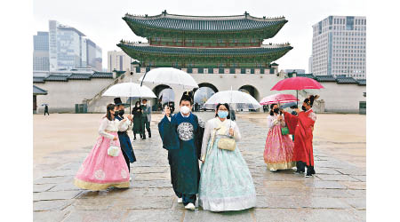 南韓旅客穿上傳統服飾之餘，亦不忘戴上口罩。（美聯社圖片）