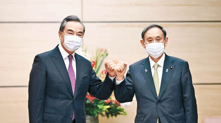 王毅（左）與日本首相菅義偉（右）會晤。（美聯社圖片）