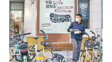 北京市民在宣傳澳洲牛肉的海報前走過。