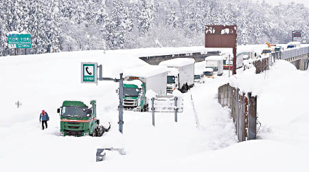 新潟縣大塞車，有拖頭困在雪堆中。（美聯社圖片）