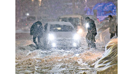 日本西部地區出現暴雪，有汽車困在雪地中無法行駛。（美聯社圖片）