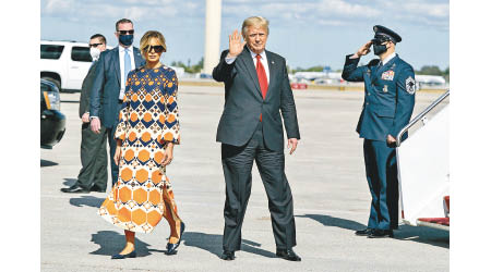 與妻子（前左）步出空軍一號後，特朗普（前右）向在場人士揮手。（美聯社圖片）