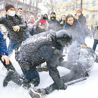 警員與示威者在雪地上扭作一團。（美聯社圖片）