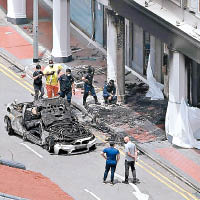 房車遭燒焦，警員在車禍現場調查。（海峽時報圖片）