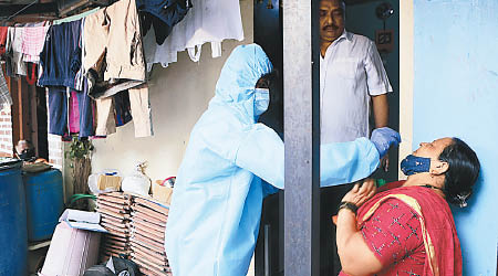 印度防疫人員替民眾採集深喉樣本化驗。（美聯社圖片）
