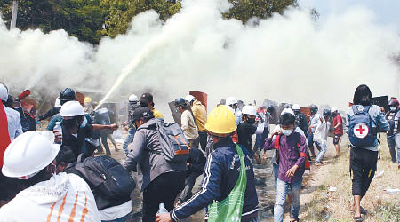 內比都示威者在警方施放的催淚彈下撤退。（美聯社圖片）