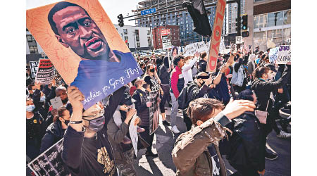 示威者高舉弗洛伊德的肖像，在法庭外抗議。（美聯社圖片）