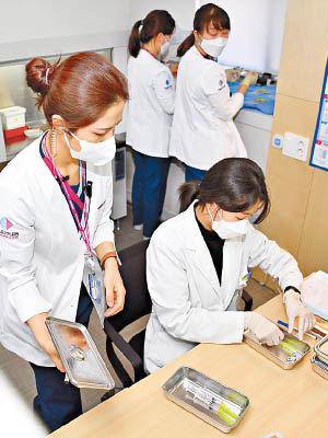 南韓開展全國新冠疫苗接種計劃，醫護人員正準備替民眾注射疫苗。（美聯社圖片）