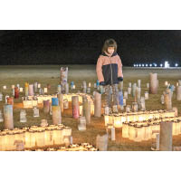 福島縣雙葉町居民在地上放滿蠟燭。