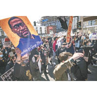 示威者高舉弗洛伊德的肖像，要求嚴懲涉案警員。
