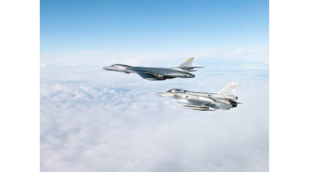 美國B1B超音速轟炸機（上）與波蘭F16戰機（下）編隊飛行。