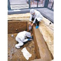 考古人員在祭祀坑內發掘文物。