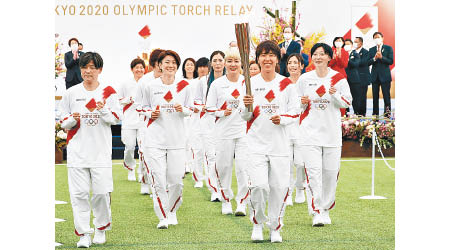 日本女子足球隊成員擔任第一棒火炬手。（美聯社圖片）