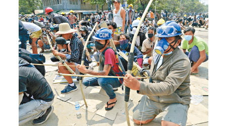 仰光示威者自製弓箭對抗軍警。（美聯社圖片）