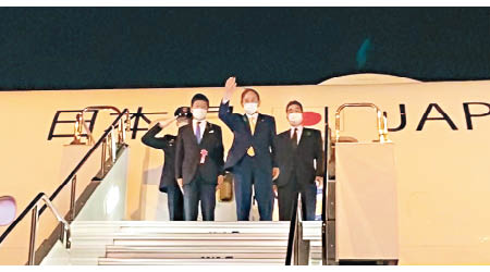 日本首相菅義偉（中）登機往華盛頓進行訪問。