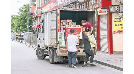 工人在廣州市番禺搬運物資。（中新社圖片）