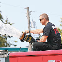 西雅圖以北的埃弗里特消防員開啟滅火水龍頭，替民眾降溫。