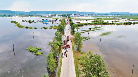 黑龍江洪水氾濫，消防員到三卡鄉加固堤壩。