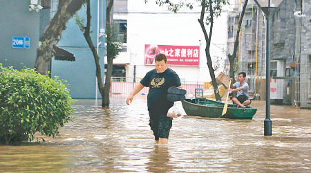 柳州市的市民被迫涉水而行。（中新社圖片）