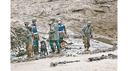 自衞隊隊員帶同搜救犬搜索。