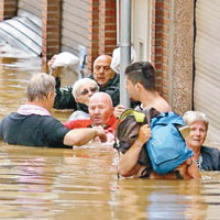 比利時：列日市市民在水中等待救援。