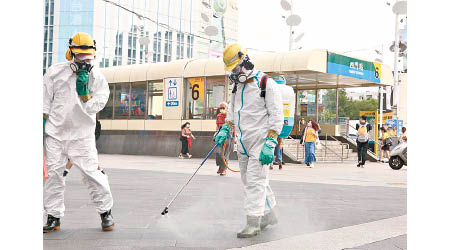 職員於台北市西門站外進行消毒工作。