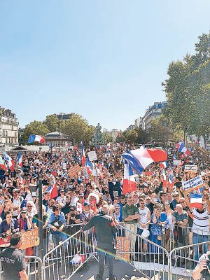 巴黎示威者脫下口罩，舉起橫額標語示威。