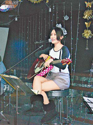 小花在台上自彈自唱，表現穩定。