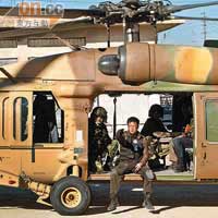 安志杰穿上厚厚的軍服在直升機上拍攝。