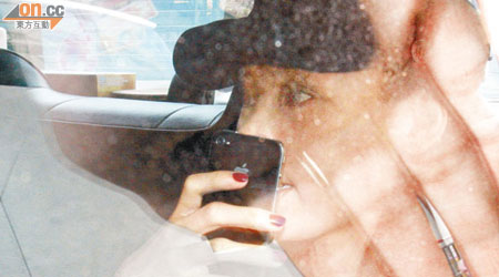 栢芝乘的士離開時，見記者拍照即用手機掩面避鏡。