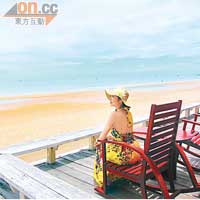 陳自瑤穿露背花裙，坐在露台對住大海拍照，很有詩意。