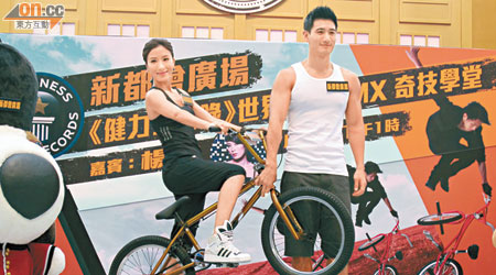 Jin單手托起單車，讓楊怡「表演」花式動作。
