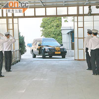 繫上黃色絲帶的靈車抵達殯儀館時，有身穿白色制服的工作人員向車內的惠天賜敬禮。