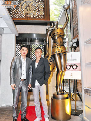 溥儀眼鏡行政總裁邱子傑（左）帶同梁家輝參觀旗艦店內擺放的3.2米巨型獎座。