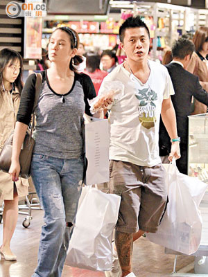 陳見飛與男友各自拿着大袋食物離開超市。