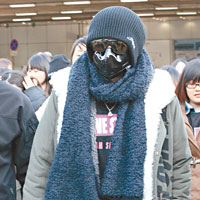 小豬步出北京機場時，戴防毒面罩由頭包落腳。