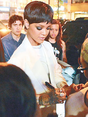 Rihanna於女粉絲胸上簽名。（東方IC圖片）
