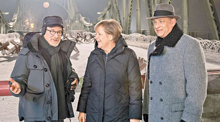 湯漢斯（右）與史匹堡去年12月在德國拍新戲，並與德國總理默克爾合照。（東方IC圖片）